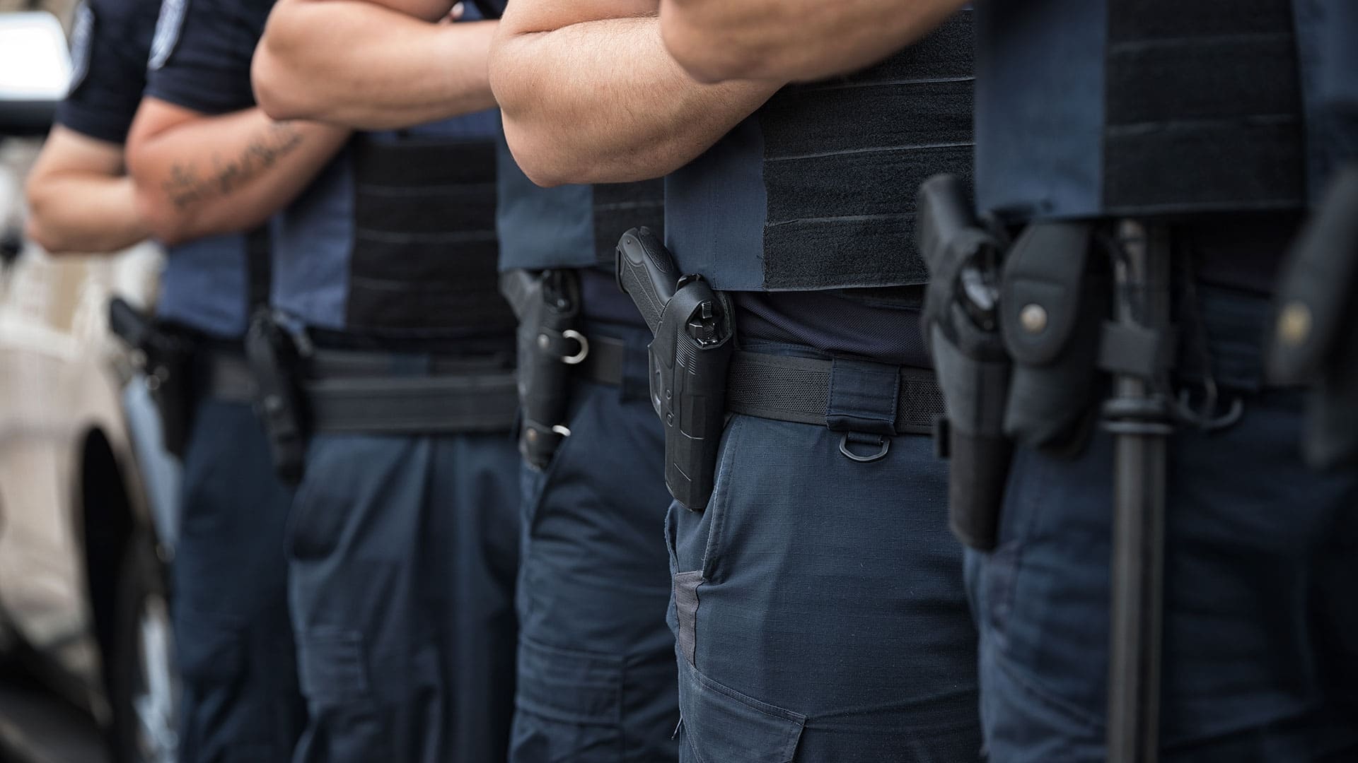 Close up de personal uniformado de una empresa de seguridad privada, portando su armamento.